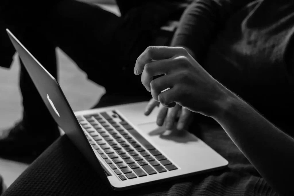 Mains sur un ordinateur portable en noir et blanc, erreurs de création de site web